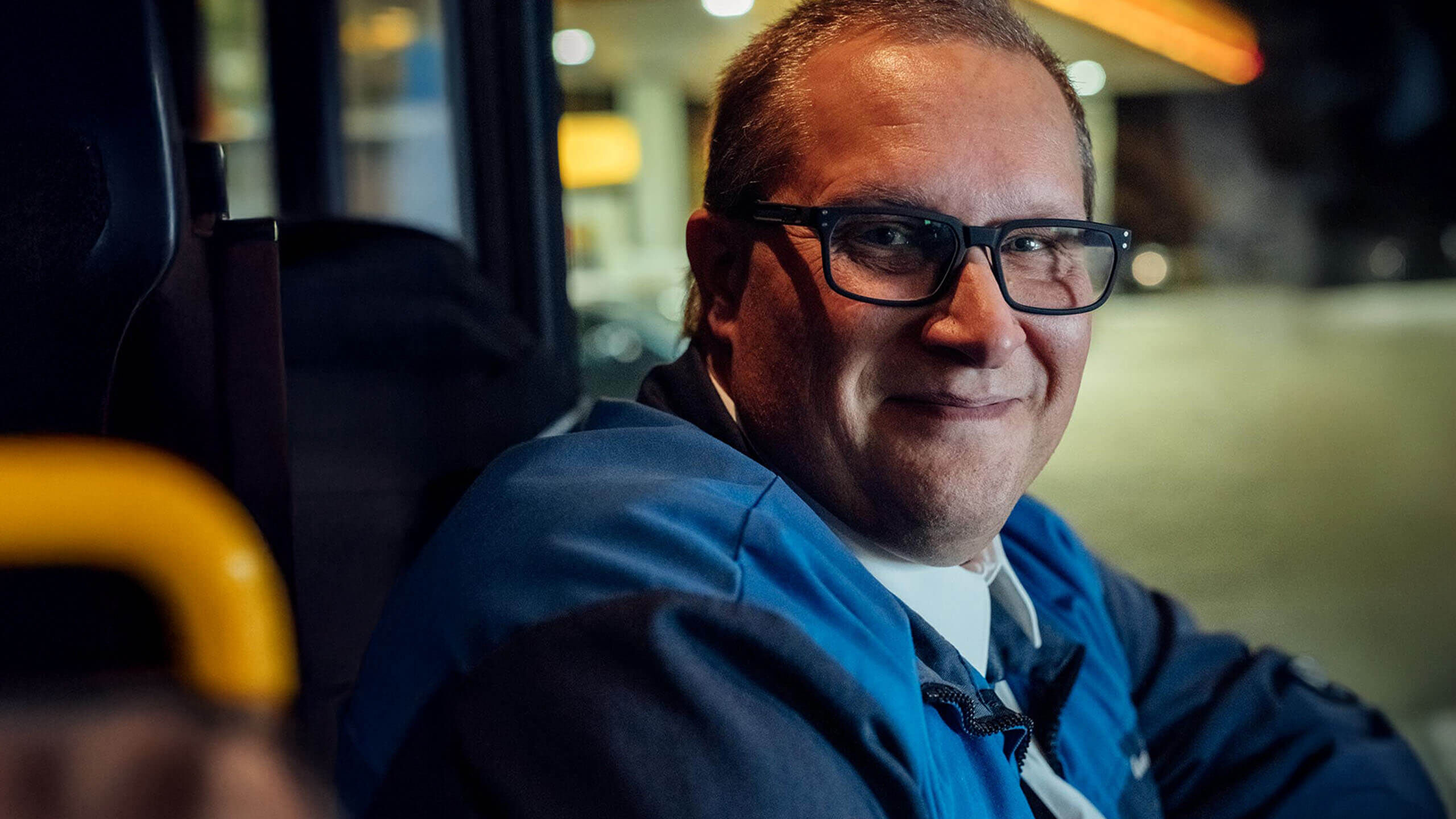 Bussikuski ajolasit päässä ajamassa bussia